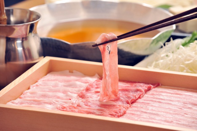 薄切り豚肉を掴む箸